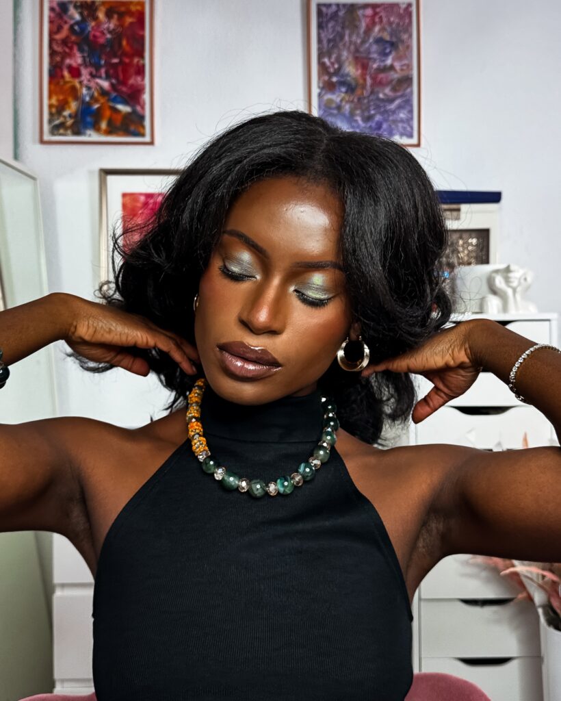 Self portrait with green sparkle eye make up wearing green accessories.