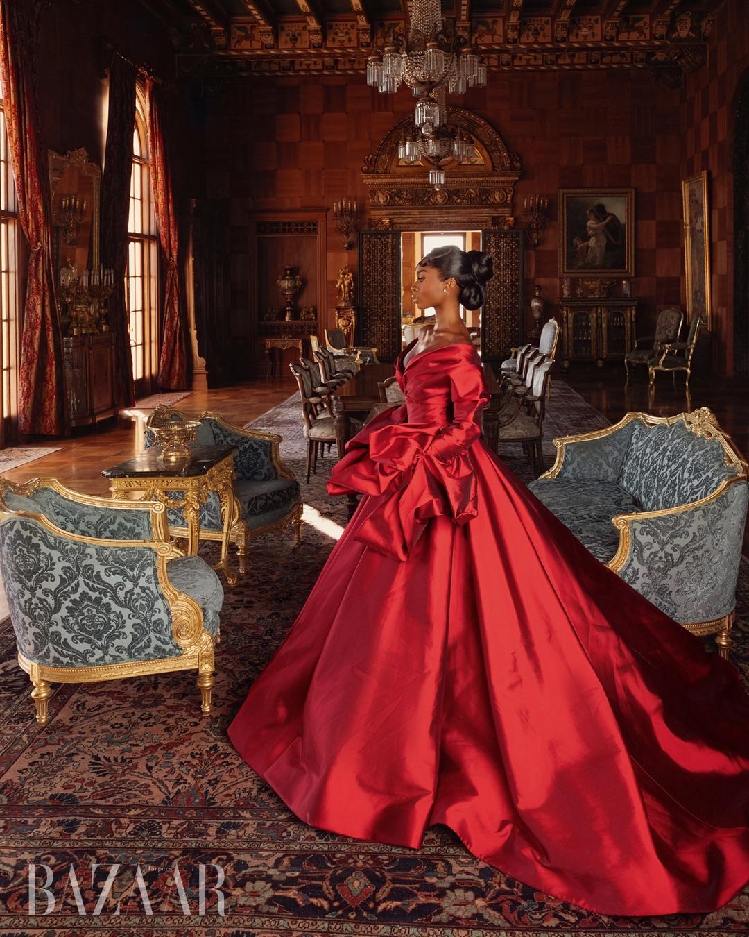 Olandria dressed in a red gown in a luxurious room